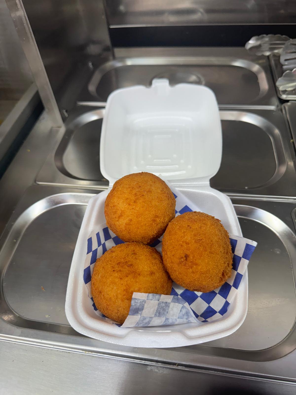 Papas rellenas — stuffed fried potato croquetas in a takeout container