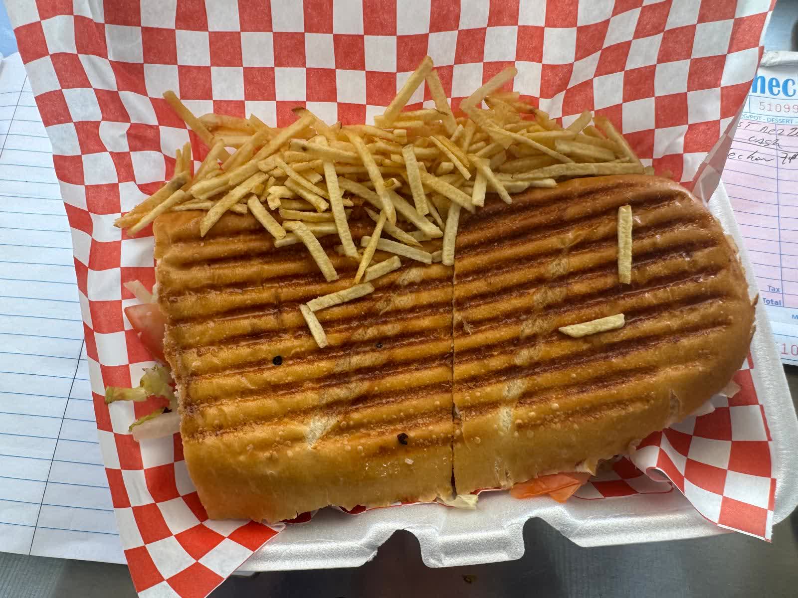 Pressed Cuban sandwich topped with shoestring fries